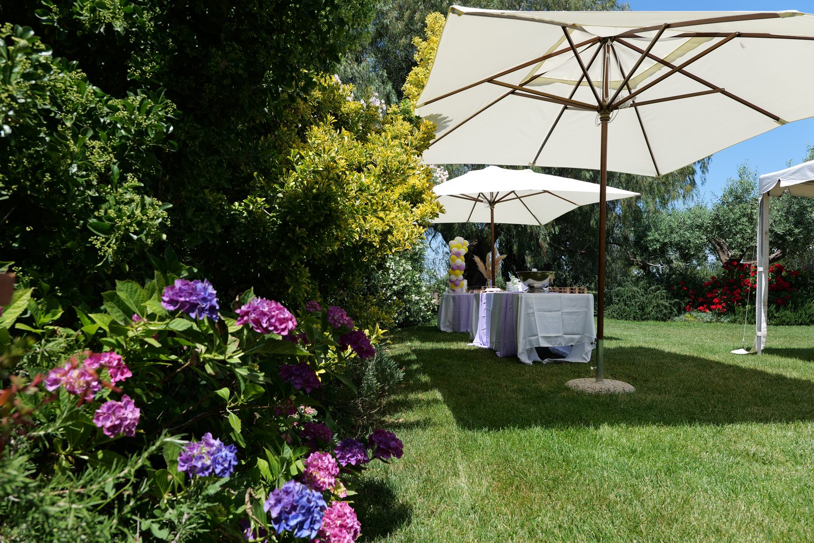 Fiori, ombrelloni e tavoli esterni in giardino